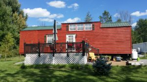 Completion picture of the Park model trailer with wood siding restoration. Also new rustic shudders are installed. 